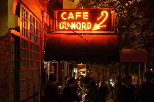 Vibrant Cafe Du Nord entrance with neon sign, perfect for social gatherings and networking.