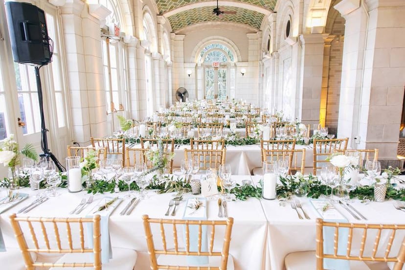 Elegant banquet setup at The Boathouse, featuring white linens and gold chiavari chairs.