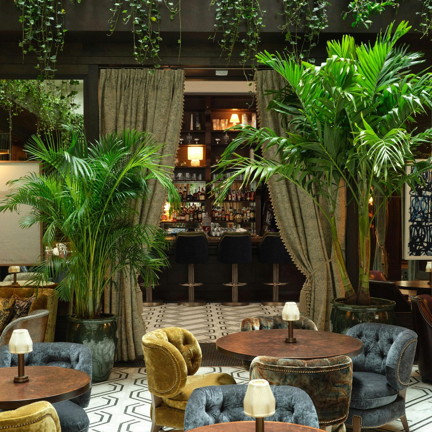 Elegant dining room at The Ned, featuring lush greenery for events and gatherings.