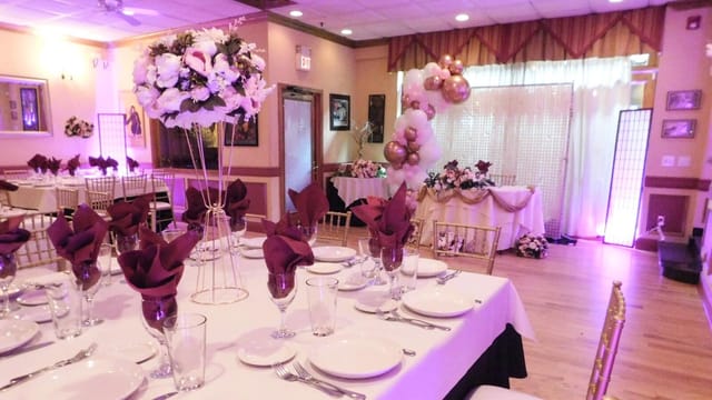 Elegant party room with white tablecloths, ideal for weddings and corporate events.