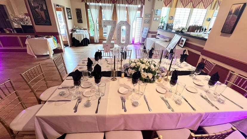 Elegant dining table with floral centerpieces for a 70th birthday celebration.