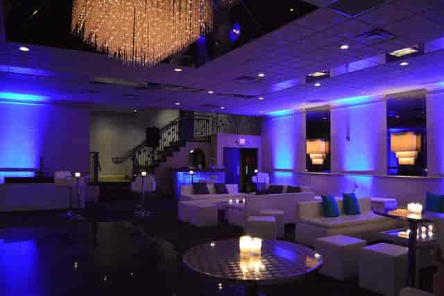 Stylish event space with modern seating and blue lighting for upscale receptions.