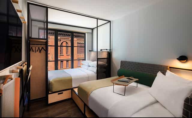 Modern hotel room with two beds in Moxy East Village, ideal for business travelers.