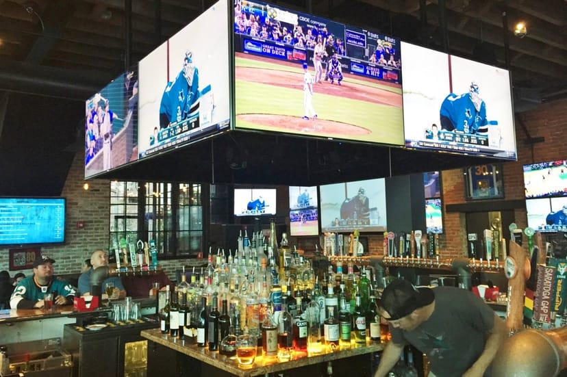 Vibrant sports bar patio with screens, ideal for networking events and watch parties.