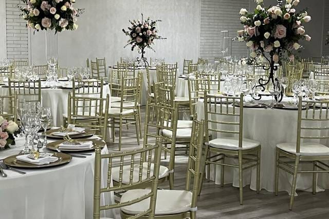 Elegant Casablanca banquet hall with white tables and gold chairs, perfect for weddings and galas.