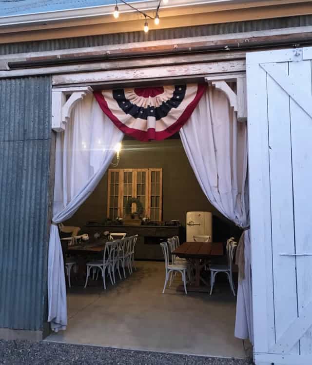 Charming rustic event space in The Warehouse, Nevada with elegant drapery and wooden tables.