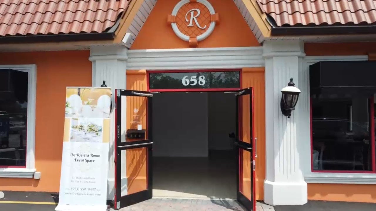 Vibrant Riviera Room entrance with orange facade, ideal for meetings and celebrations.