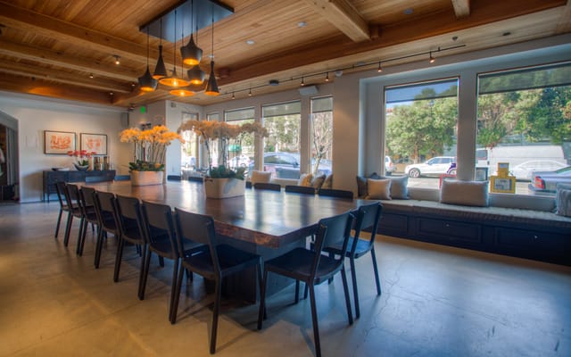 Stylish meeting space with wooden table and black chairs, ideal for gatherings and brainstorming.