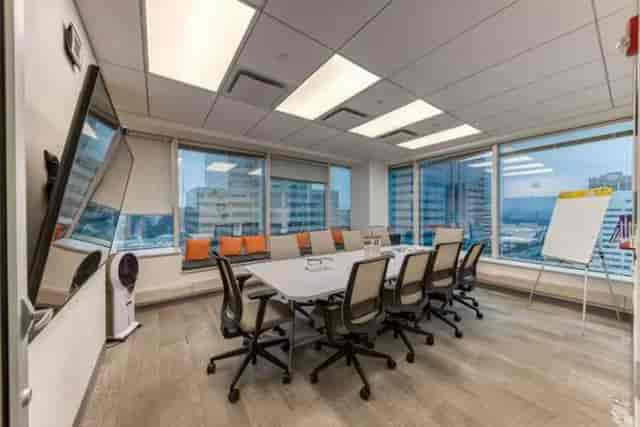 Modern conference room with large table and city view, ideal for meetings and collaboration.