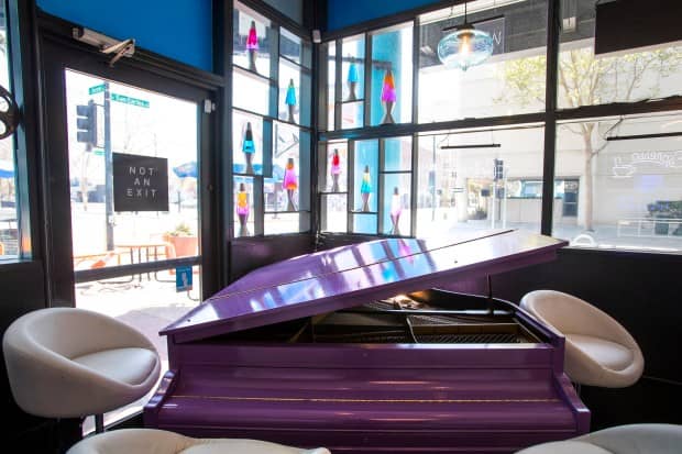 Vibrant café with purple piano, modern seating for creative events and gatherings.