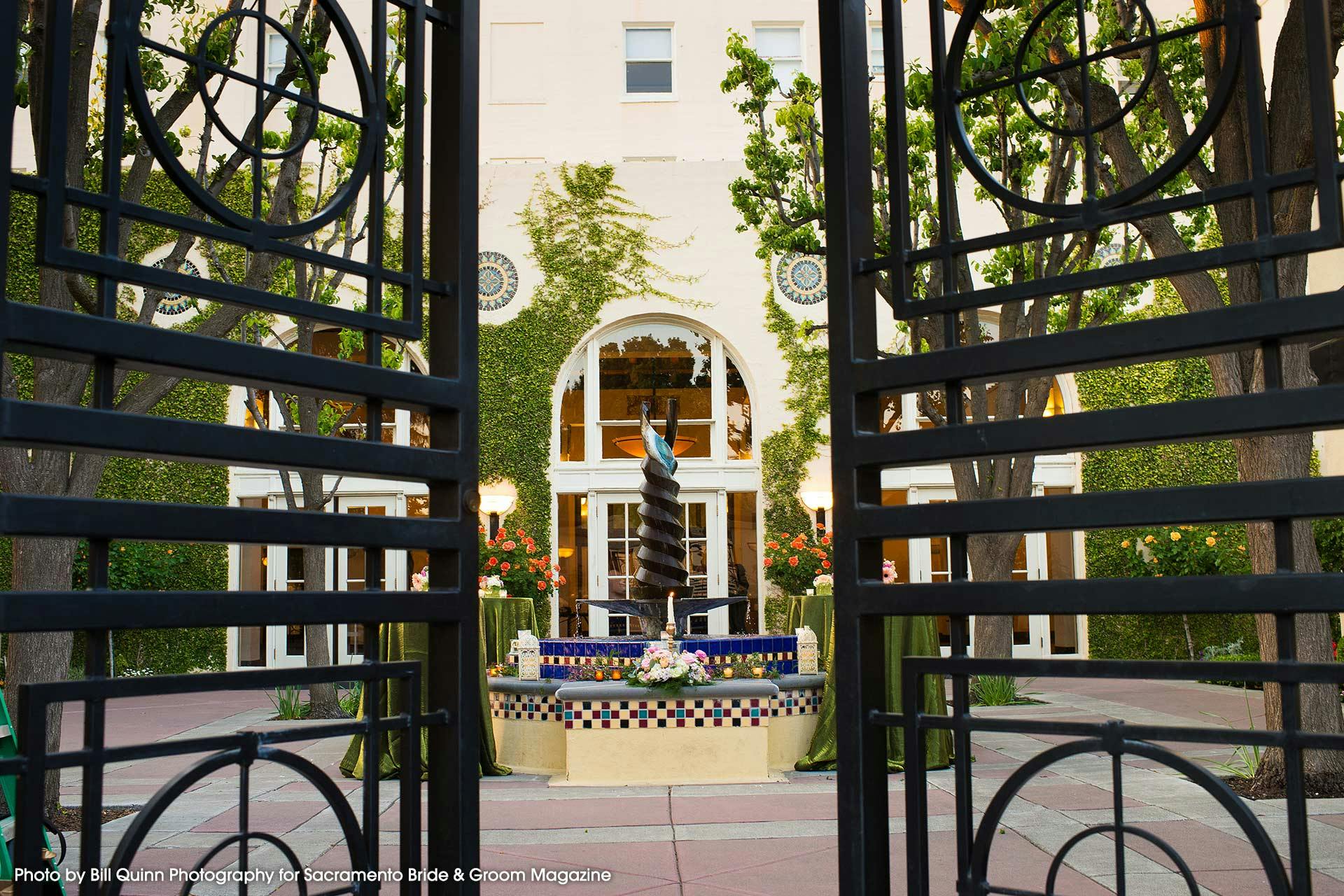 Enclosed patio with elegant gates and fountain, perfect for outdoor events at Historic Hotel Woodland.