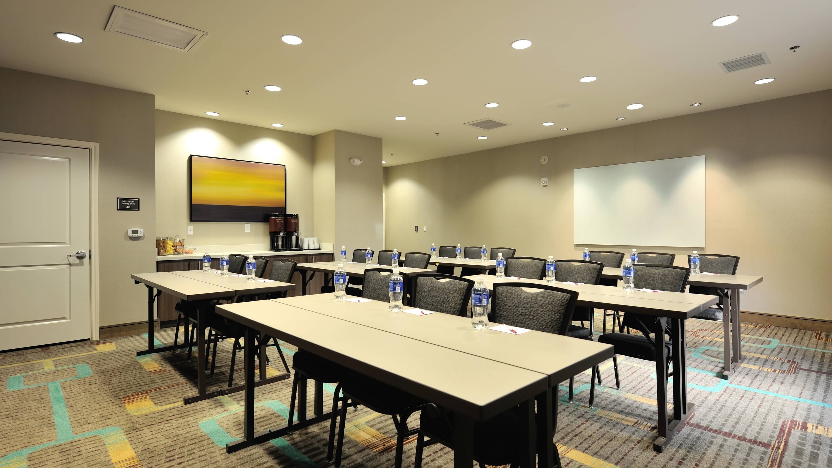 Meeting room with classroom setup, natural light, ideal for professional events.