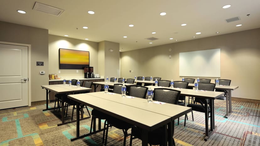 Meeting room with classroom setup, natural light, ideal for professional events.