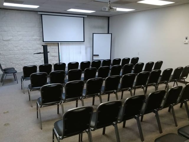 Functional conference room with black chairs for presentations and workshops.