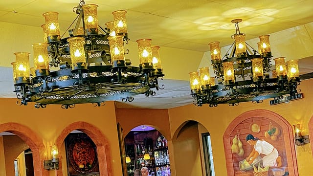 Elegant banquet hall in Casa Azteca with chandeliers, perfect for intimate events.