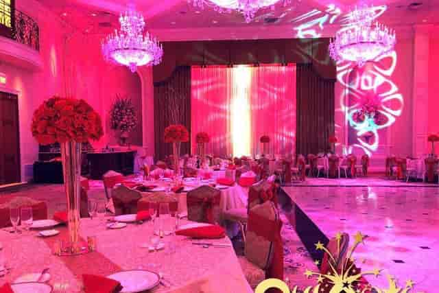 Elegant wedding setup with red accents and floral centerpieces at Quixotic Fiestas.
