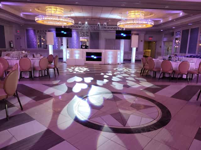 Elegant event space at Russo's On The Bay, ideal for weddings with pink chairs and ambient lighting.