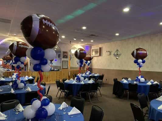 Renovated Hall at Columbus Club, decorated for a sports-themed event with football balloons.