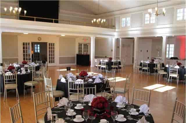 Elegant ballroom with red floral centerpieces, ideal for weddings and corporate events.
