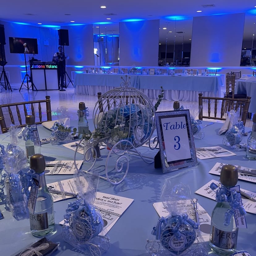 Elegant event space in Edgewater Hall with blue decor and whimsical carriage centerpiece.
