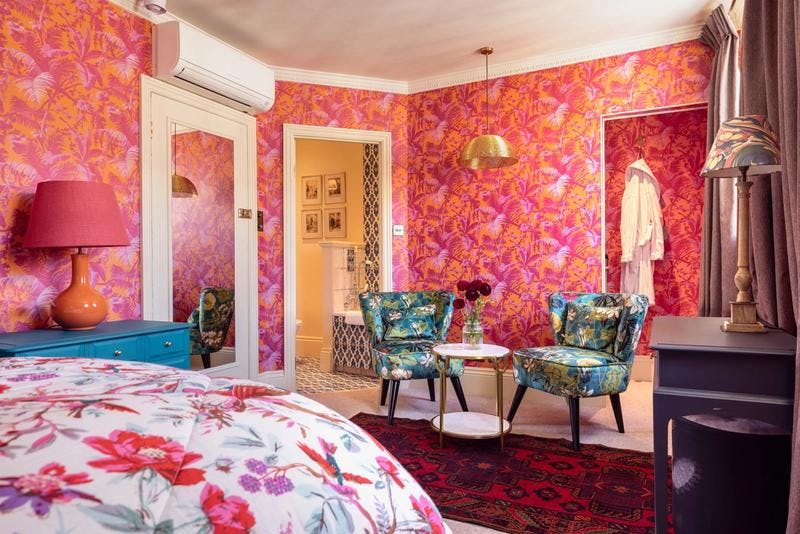 Vibrant hotel room with floral wallpaper for creative retreats and meetings.