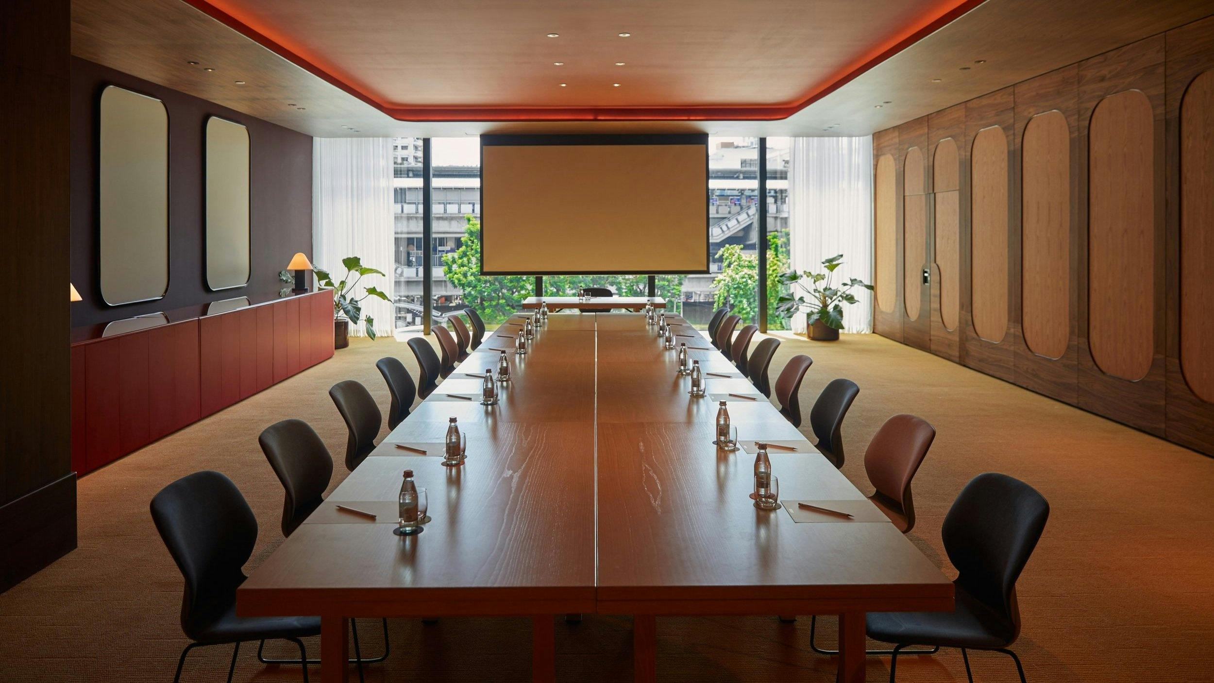 Modern conference room with wooden table, ideal for private meetings and events.