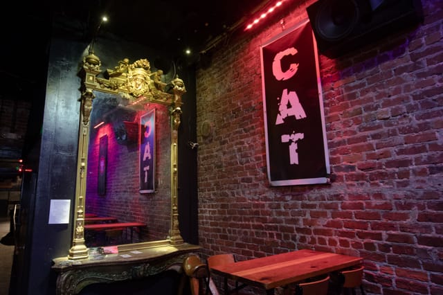 Stylish Cat Club Front Room with vintage mirror and exposed brick for events.