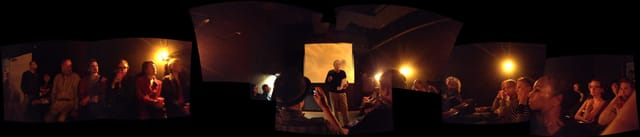 Speaker engaging audience in dimly lit Canyon Cinema for an intimate event.