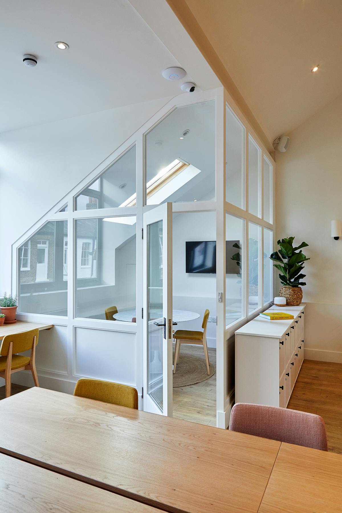 Modern meeting room with glass walls, ideal for workshops and brainstorming sessions.