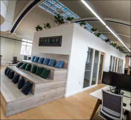 Modern private office pods with tiered seating for workshops and team-building events.