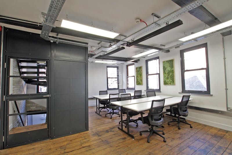 Modern coworking space with large table, ideal for workshops and team meetings.