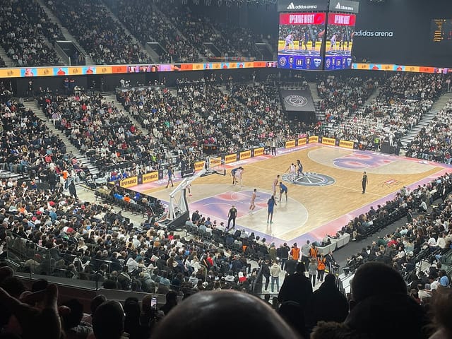 Packed basketball court at Accor Arena during a live game, showcasing vibrant fan energy.