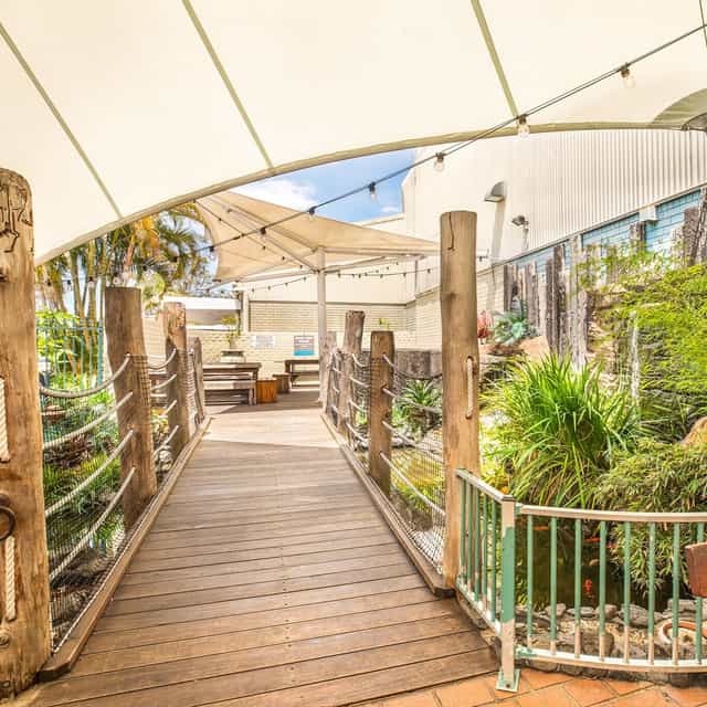 Charming outdoor event space at Jewells Tavern with lush greenery and shaded walkway.