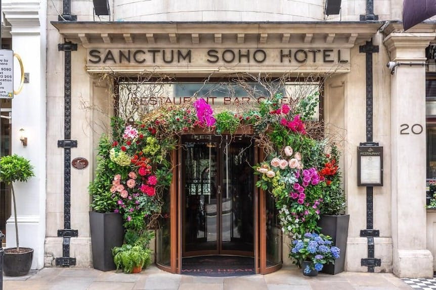 Rooftop bar entrance at Karma Sanctum Soho, London, with vibrant floral decor for events.