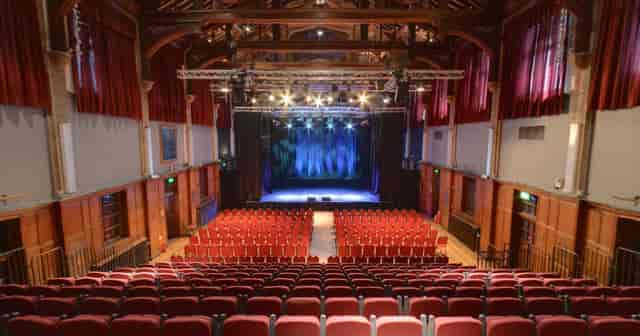 Live music venue in Harrow Arts Centre with red seating, ideal for concerts and events.