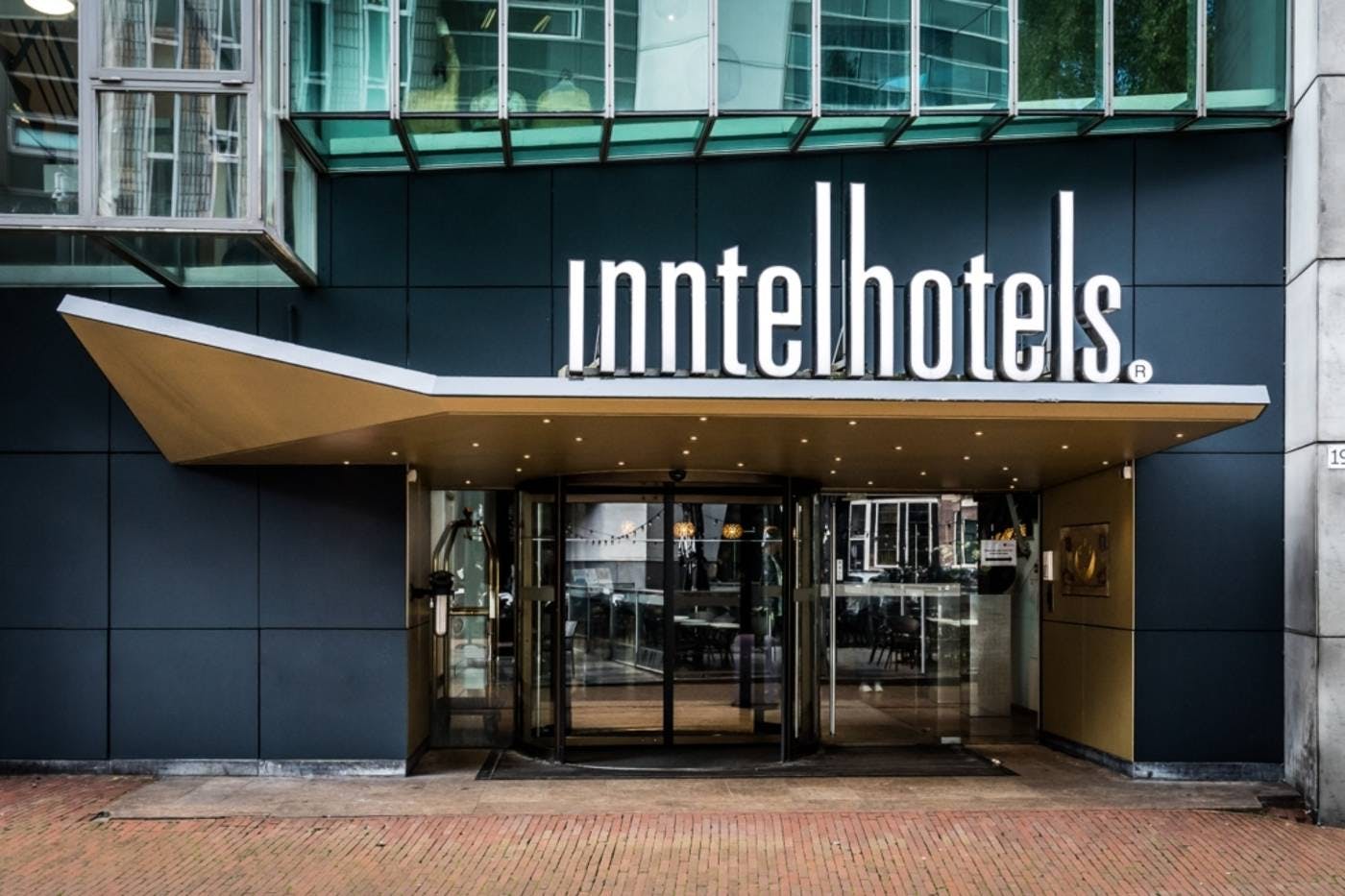 Modern hotel entrance with glass façade, ideal for corporate events in Amsterdam.
