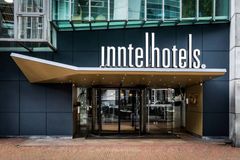 Modern hotel entrance with glass façade, ideal for corporate events in Amsterdam.