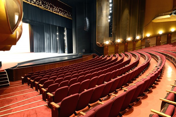 Auditorium with plush red seating in PETE BE CENTER for conferences and performances.