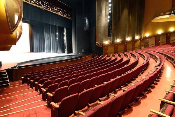 Auditorium with plush red seating in PETE BE CENTER for conferences and performances.