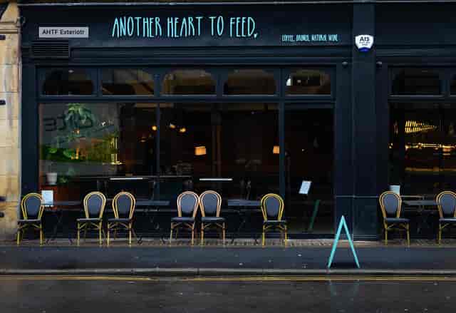 Charming venue exterior with outdoor seating for intimate gatherings and networking events.