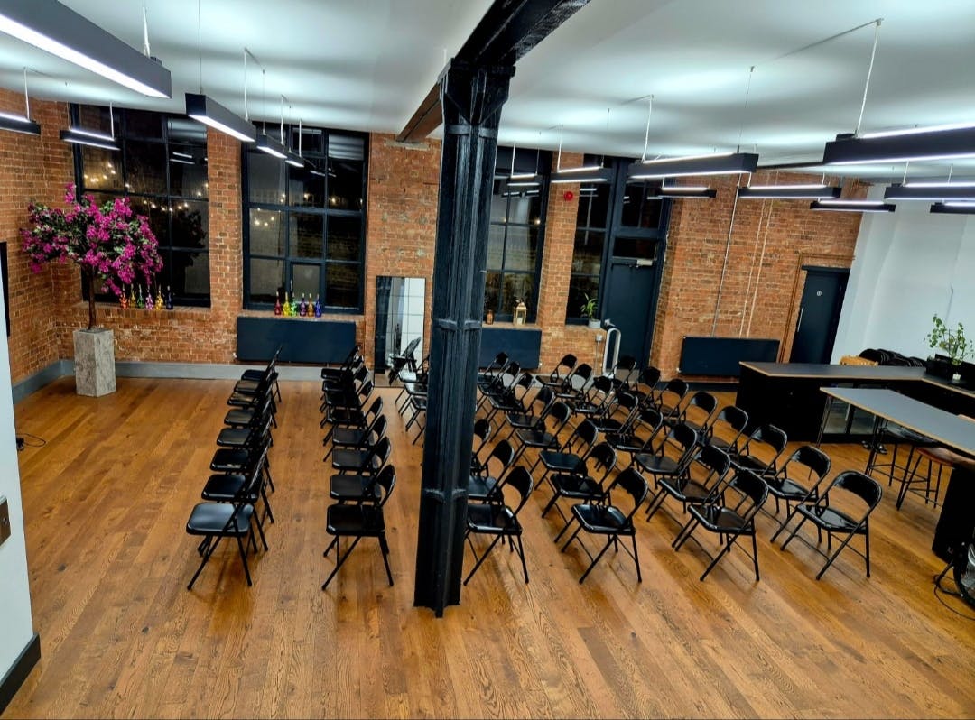 Modern industrial event space with exposed brick, ideal for workshops and corporate meetings.