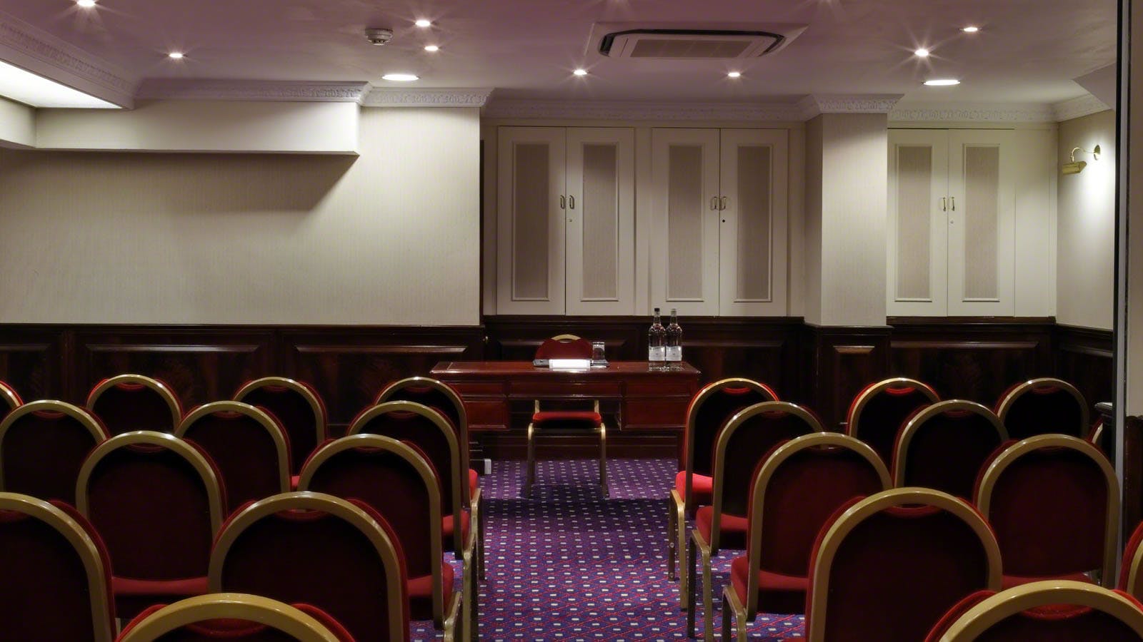 Rochester Suite meeting room with red chairs, ideal for presentations and small events.