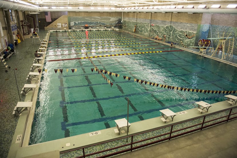 Indoor swimming pool with lanes and diving boards for aquatic competitions and training.