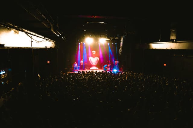 Vibrant live event at The Factory in Deep Ellum with dynamic lighting and heart backdrop.