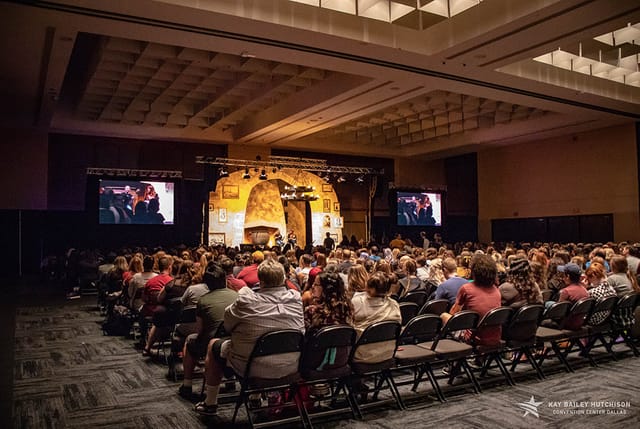 "Ballroom A at Kay Bailey Hutchison Convention Center with audience at a conference presentation."