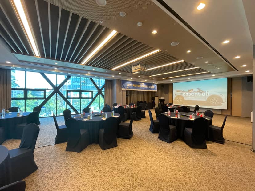 Modern meeting room in voco Seoul Gangnam, featuring round tables for events and presentations.