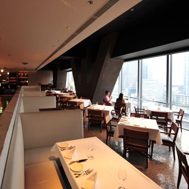 Modern restaurant interior at XEX TOKYO with city skyline view, ideal for events.