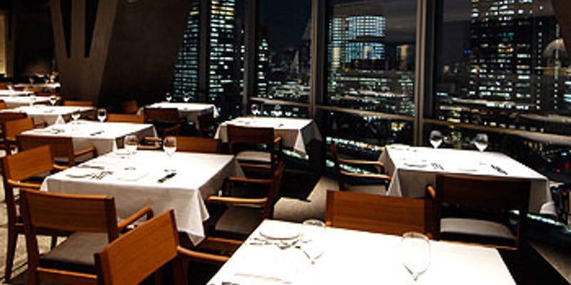 Sophisticated dining at XEX TOKYO with city skyline view, perfect for upscale events.