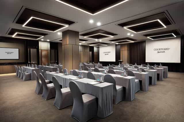 Corporate meeting room at Courtyard Marriott Seoul with modern furnishings and dual screens.