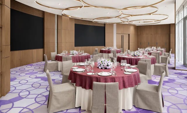 Elegant event space at Park Hyatt Seoul with round tables and rich burgundy linens.